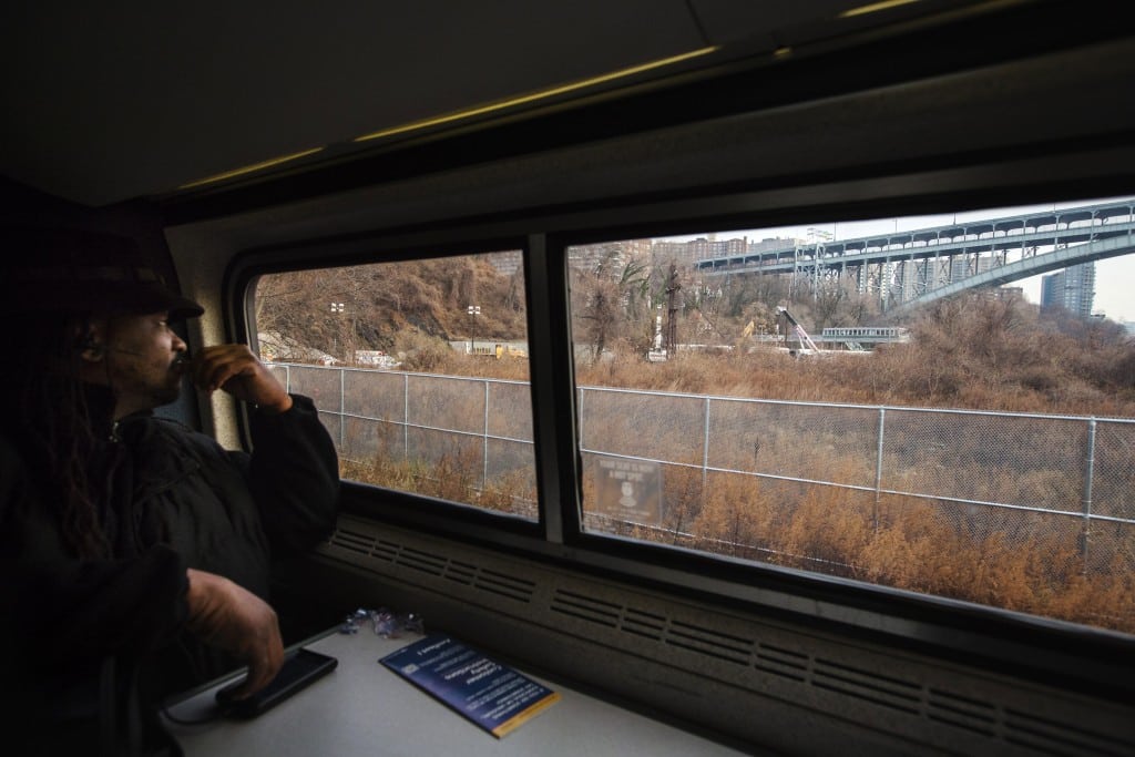 Passenger James Earl looks out of the window of an Amtrak train as it passes the site of a derailed Metro-North Railroad train in New York, December 2, 2013. 