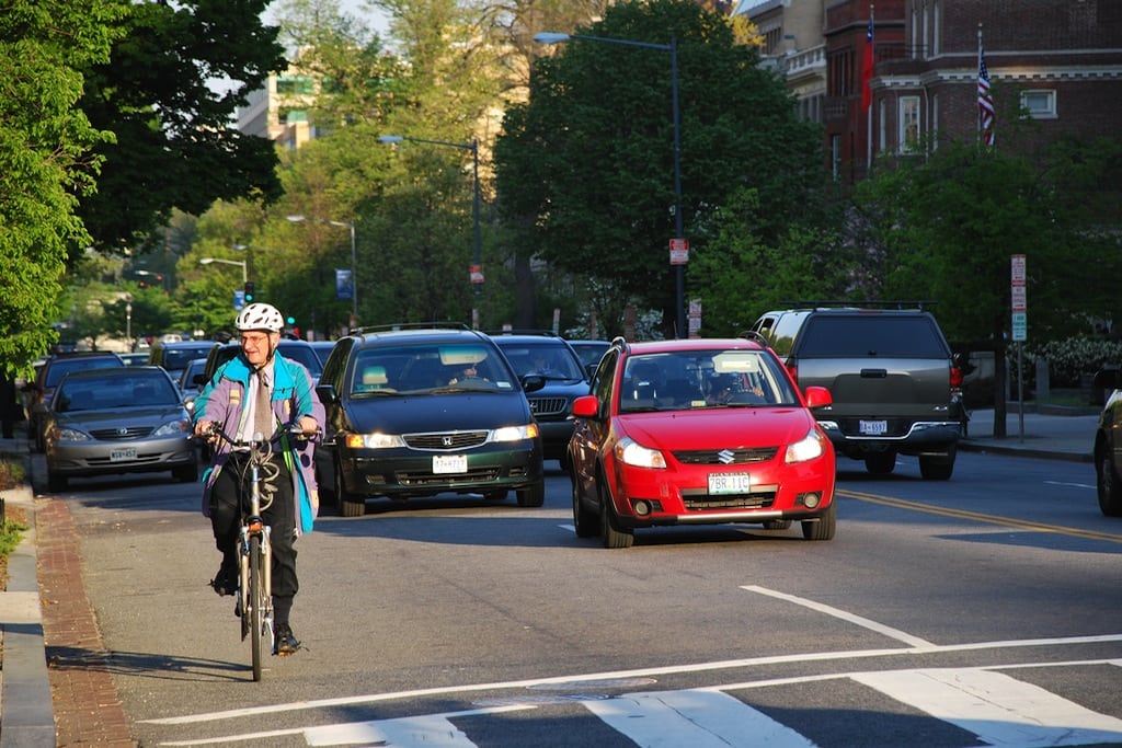 A man bikes next to commuter traffic on Massachusetts Avenue in Washington, D.C. 