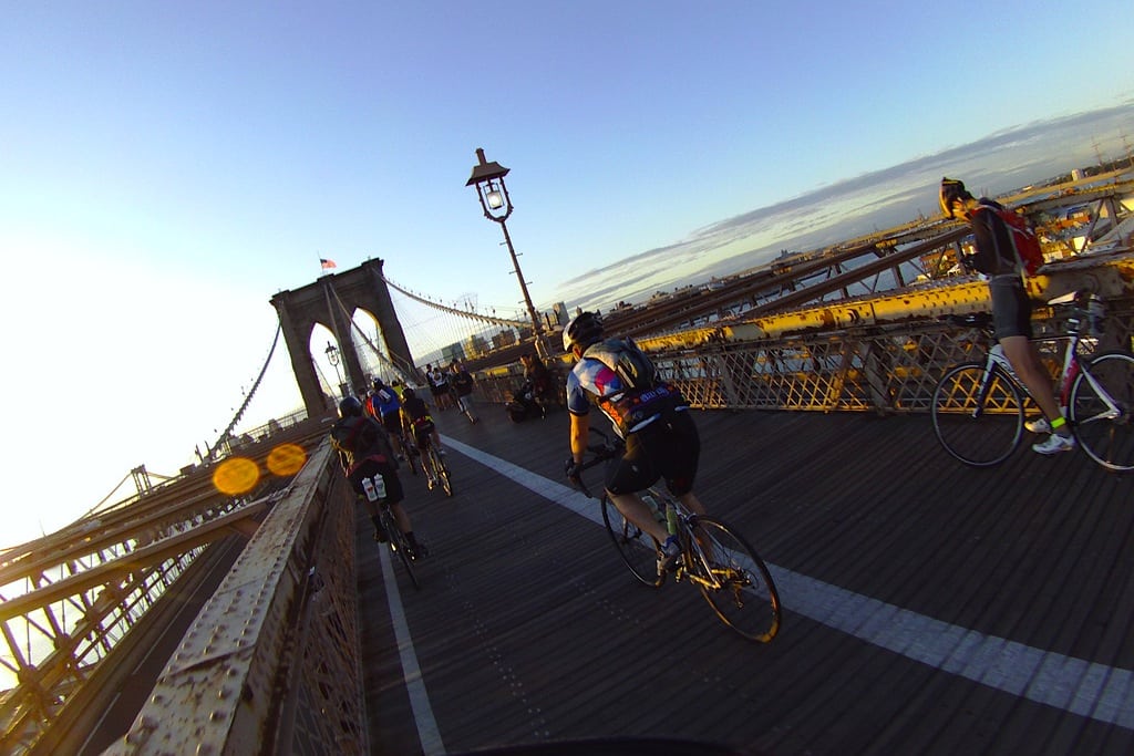 Bike riders on the Brooklyn Bridge before sunrise.