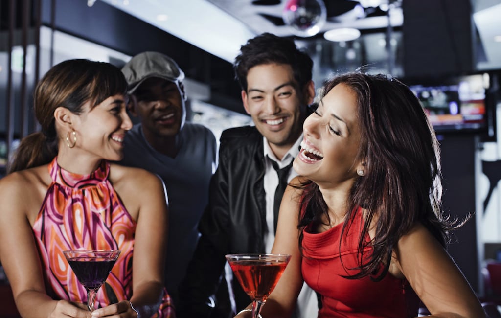 Friends drinking in a nightclub at an Aloft property.