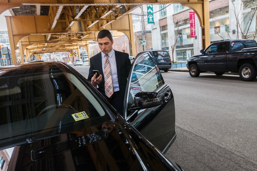 Limousine driver Florian Bucea checks his Uber service in Chicago, Illinois, on March 25, 2013. The service allows riders to schedule service through a phone app and dispatches drivers. The company wants to expand service to the Chicago suburbs