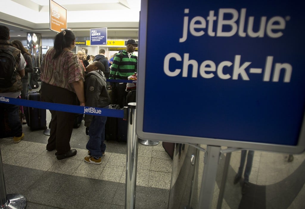 People wait in line at the JetBlue counter at La Guardia airport in New York. 