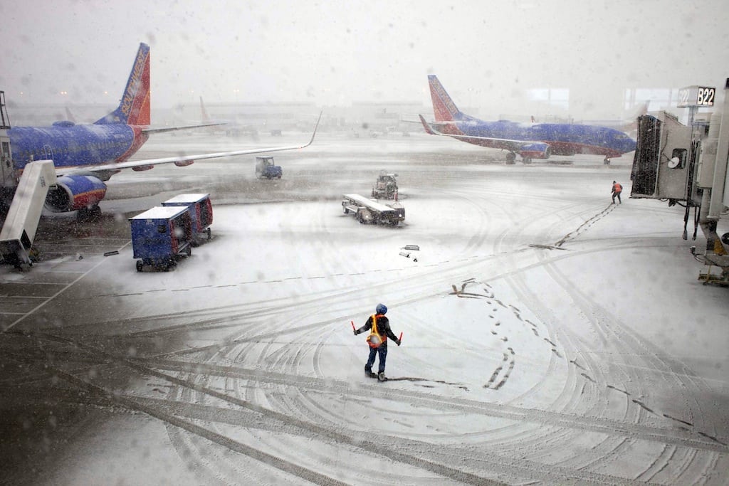Southwest Airlines employees guide a plane into the gate at Midway International Airport in Chicago, Illinois, Tuesday, February 26, 2013. 