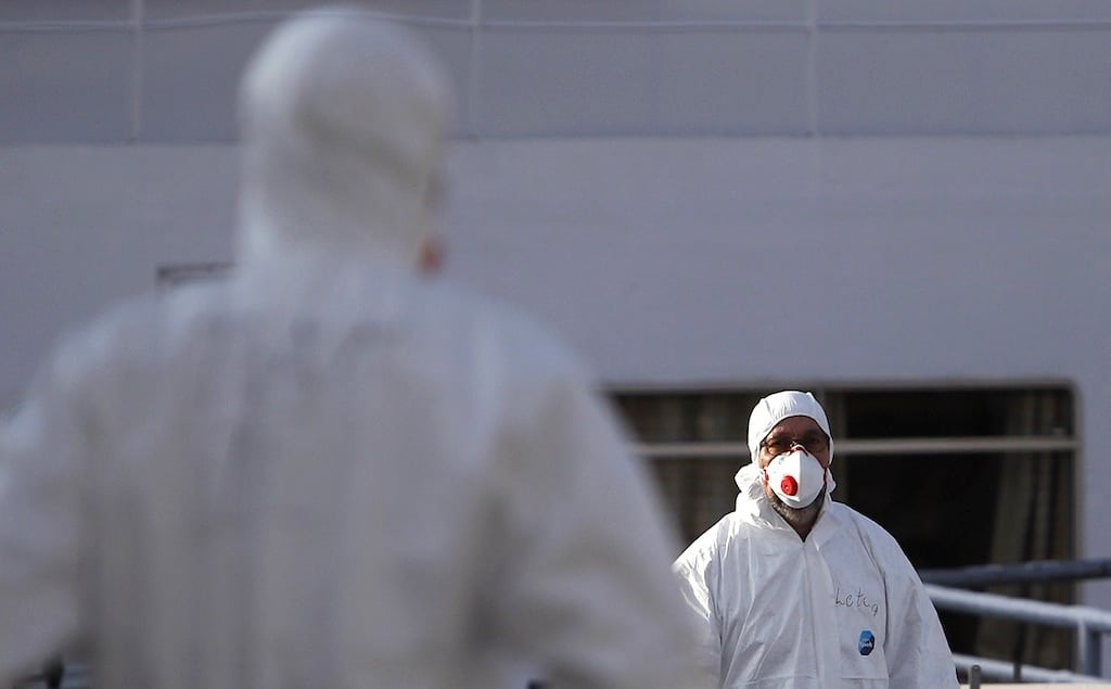 Cruise sentiment among Americans has fallen after a brief recovery, according to a Harris Poll, because of a series of norovirus outbreaks. Pictured, paramedics dressed in protective attire walk in front of the ship, the Bellriva, in Wiesbaden December 8, 2012, as the ship had to be quarantined when some 30 passengers became ill.