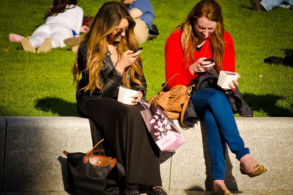 Woman look at the phones during a lunch break in London. 
