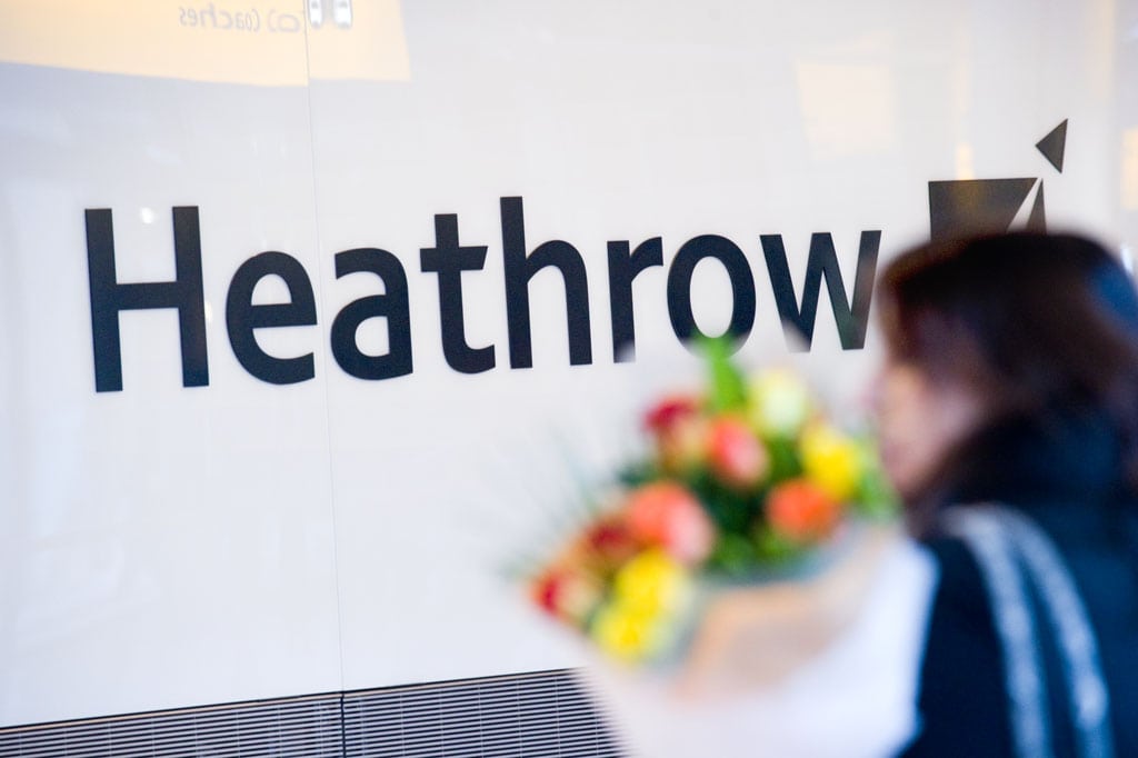 A lady waits with a bouquet of flowers in the International Arrivals concourse at Heathrow Airport's Terminal 5A.