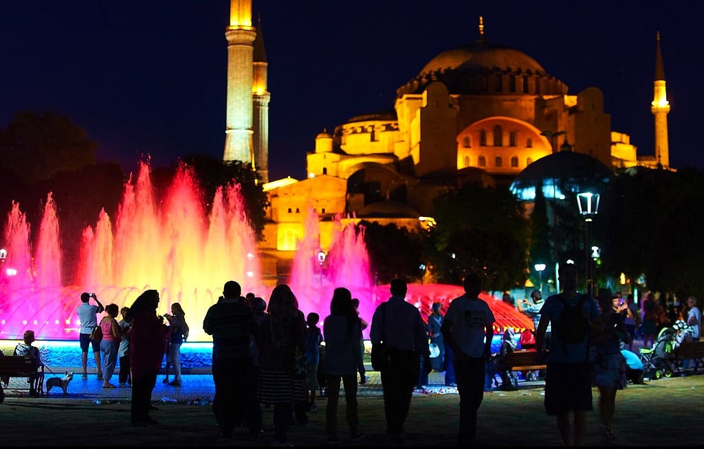 Locals and tourists walk in the main square of with Hagia Sophia in the background.