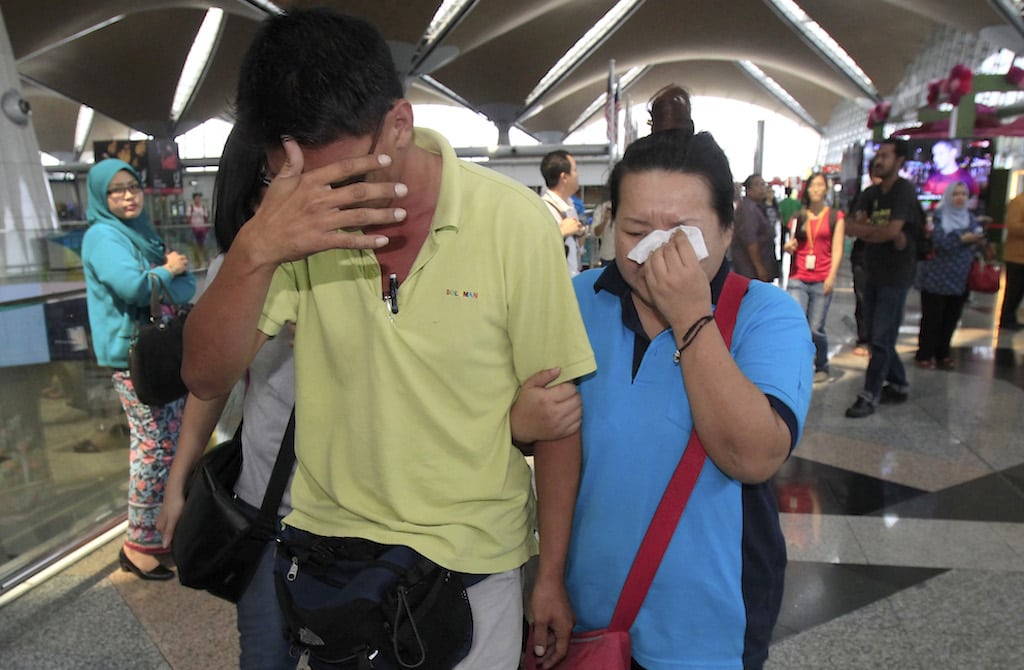 A woman wipes her tears after walking out of the reception center and holding area for family and friend of passengers aboard a missing Malaysia Airlines plane, at Kuala Lumpur International Airport in Sepang, outside Kuala Lumpur, Malaysia, Saturday, March 8, 2014.