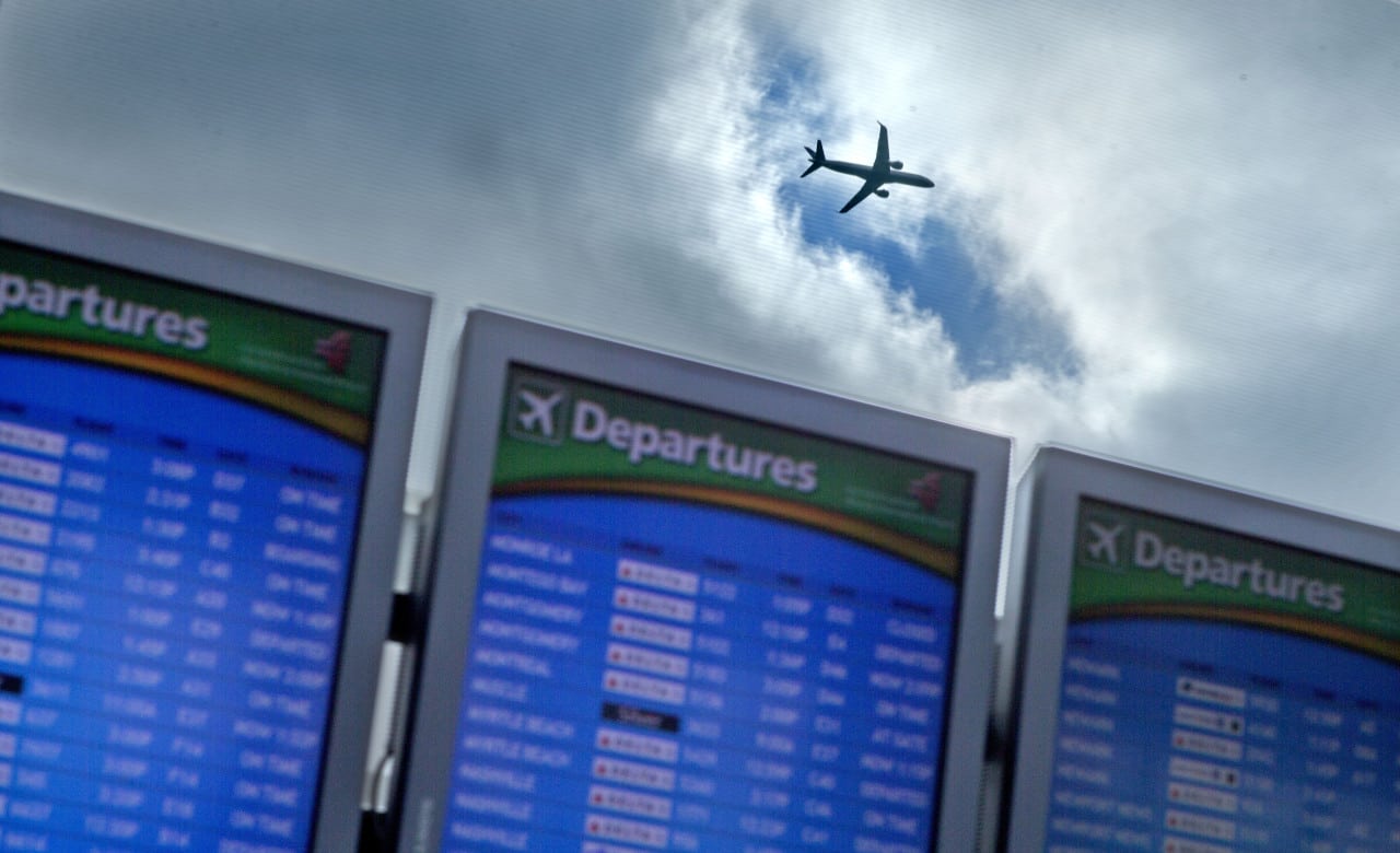 A plane takes off over a departure board at Hartsfield-Jackson Airport, in Atlanta. 