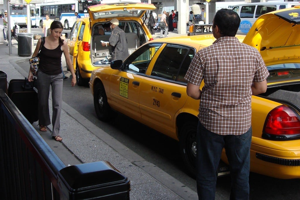 A traveler heads to a taxi at New York City JFK Airport. 
