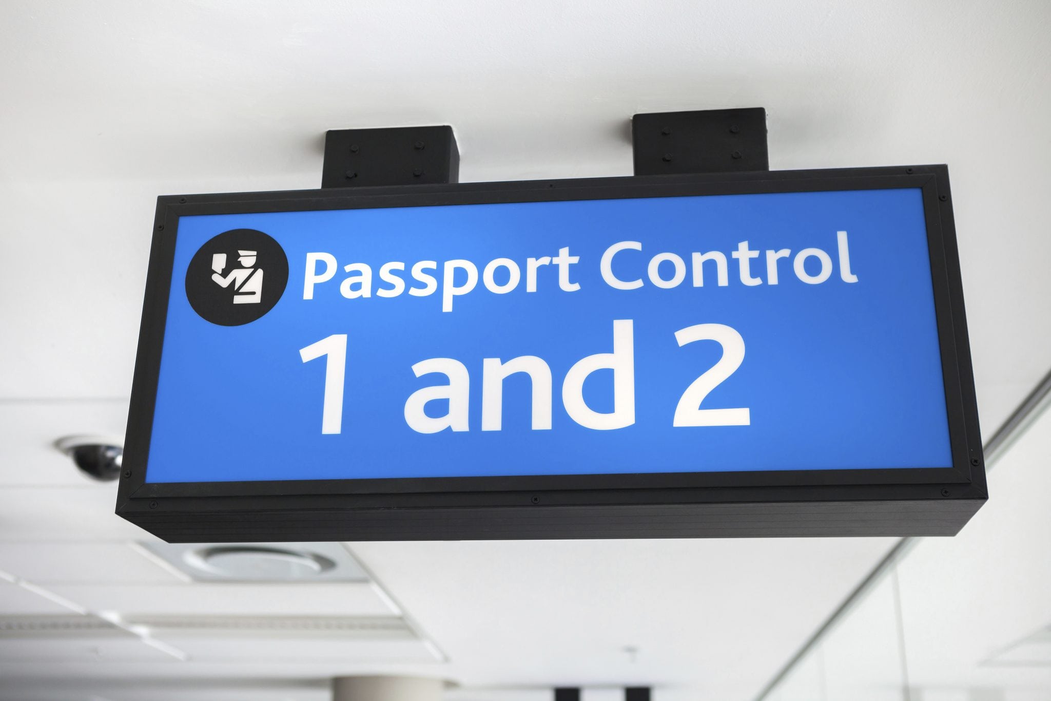 A generic blue passport control sign at an airport.
