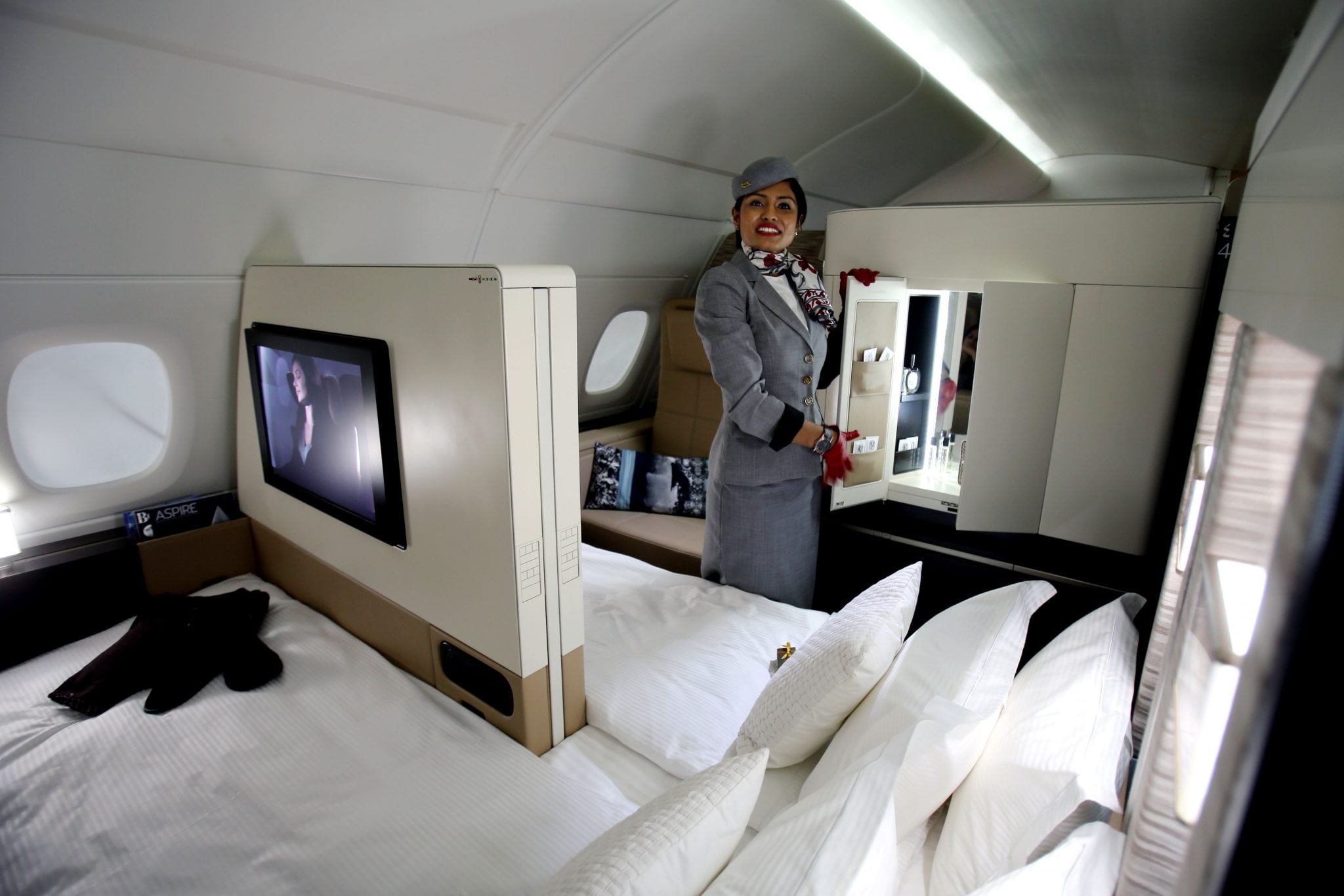 An Etihad Airways official stands inside the 125-square-foot (11.61-square-meter) area that includes a living room partitioned off from the first-class aisle, leather seating, a chilled minibar and a 32-inch flat-screen TV. 