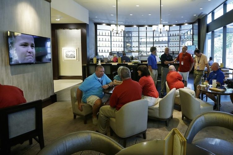 In this July 3, 2013, photo, guests socialize in the newly redesigned bar area during "social hour" at a Sheraton hotel in Seattle. Long treated as dead spaces, obbies are being transformed into places to work, surf the Web or meet friends for a drink. 