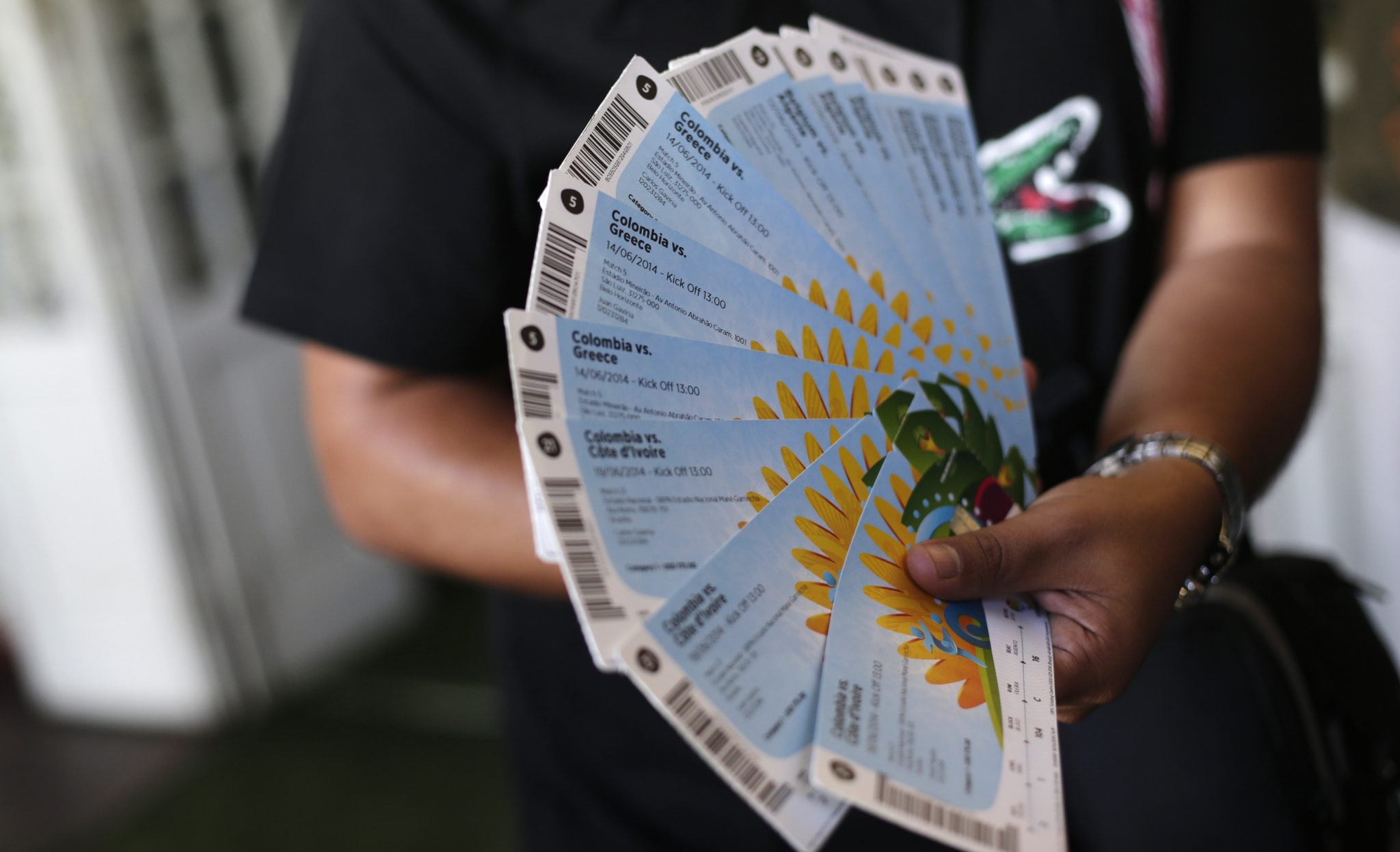 A Colombian fan displays his FIFA 2014 World Cup tickets for the match between Colombia and Greece, in Rio de Janeiro April 18, 2014.