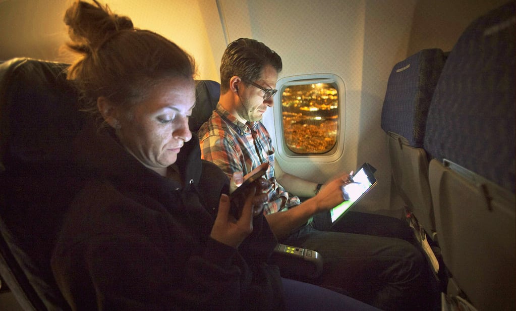 People use their smart devices on an American Airlines airplane, equipped with Gogo Inflight, enroute from Miami to New York.