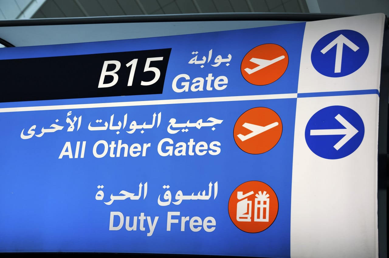 A sign in English and Arabic at Dubai Airport indicates the way to the duty free shops and all the gates. 