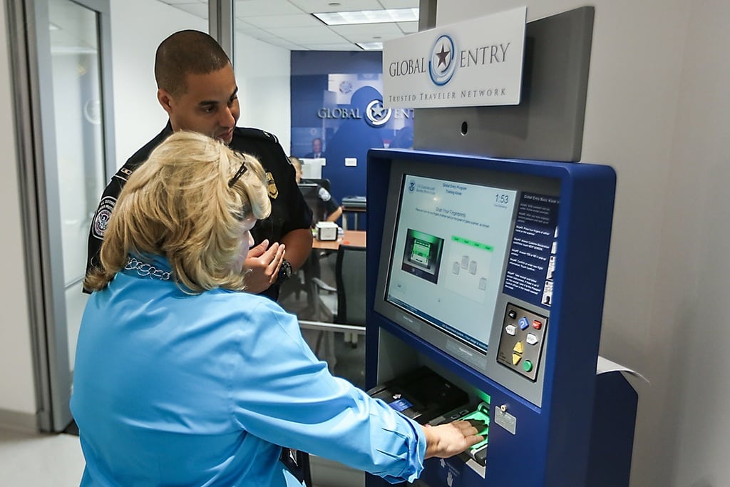 A U.S. Customers and Border Protection officer provides training to an enrollee with the use of a Global Entry kiosk located at the Ronald Reagan building in Washington, D.C. The CBP has also reduced wait times at JFK through use of kiosks.