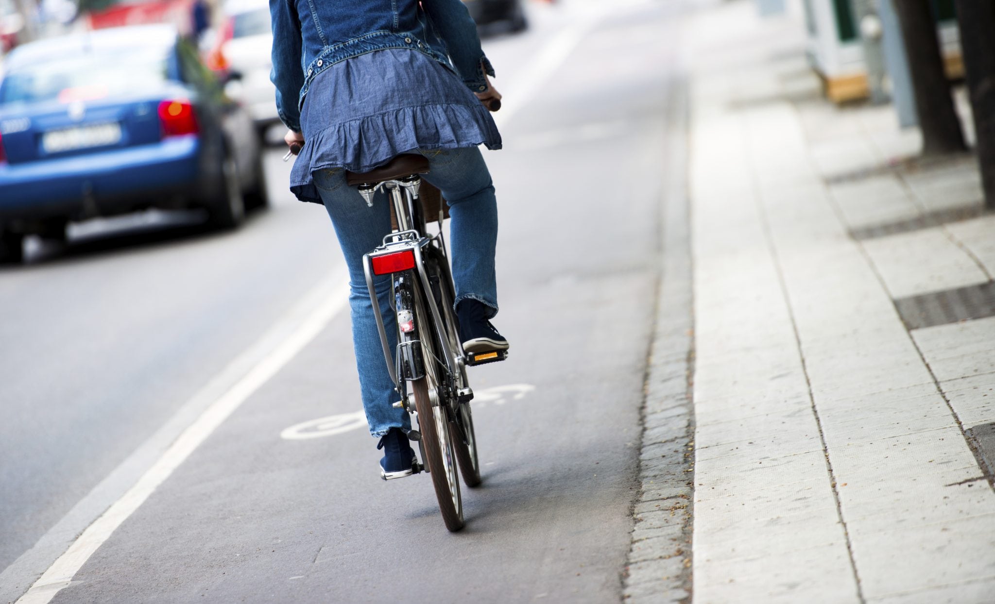 A woman rides her bike through a city.
