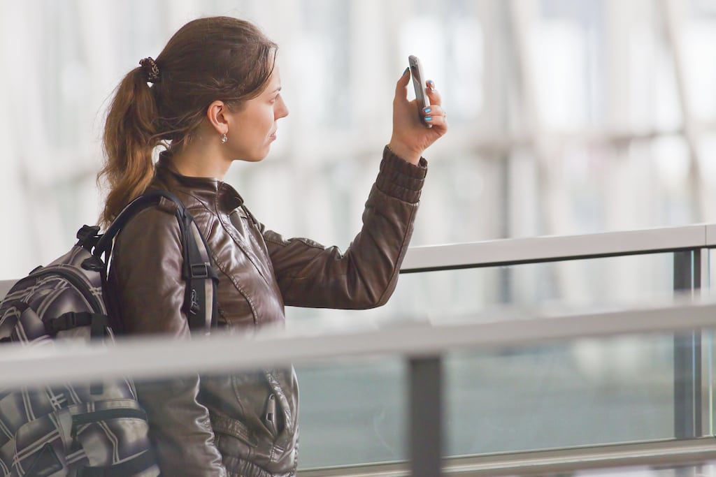 Woman talking on phone in an airport.
