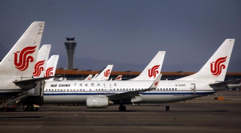 An airport worker inspects the under-carriage of Air China planes while they are parked at the terminal building of Beijing's International Airport. 