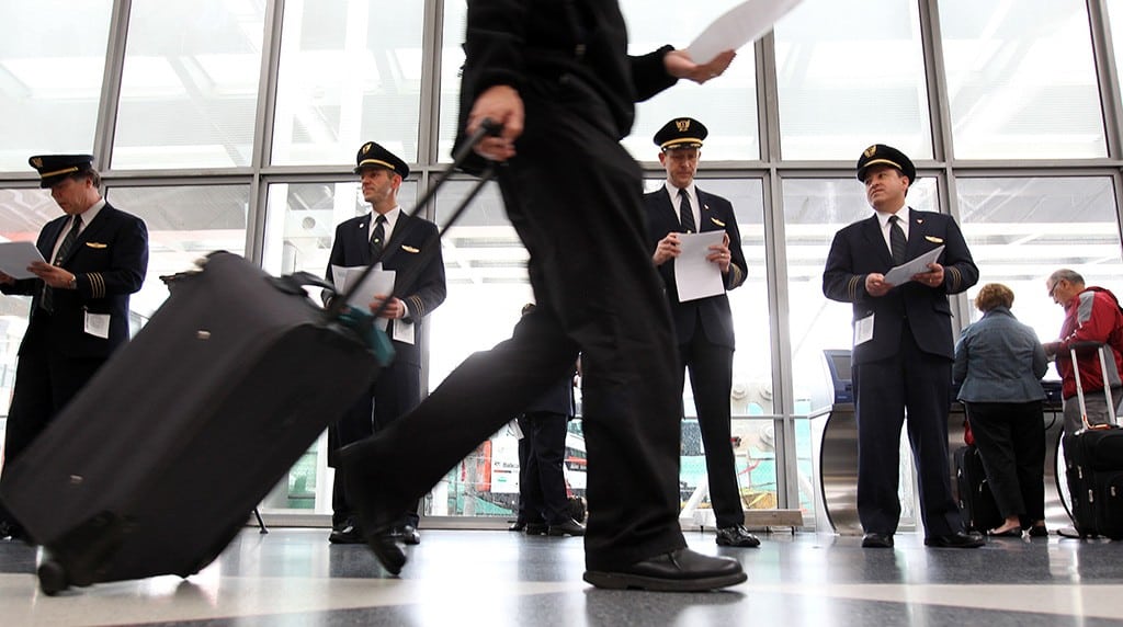 United Airline pilots pass out leaflets to passengers at O'Hare International Airport, May 7, 2012, to get their point across United's outsourcing of U.S. jobs. 
