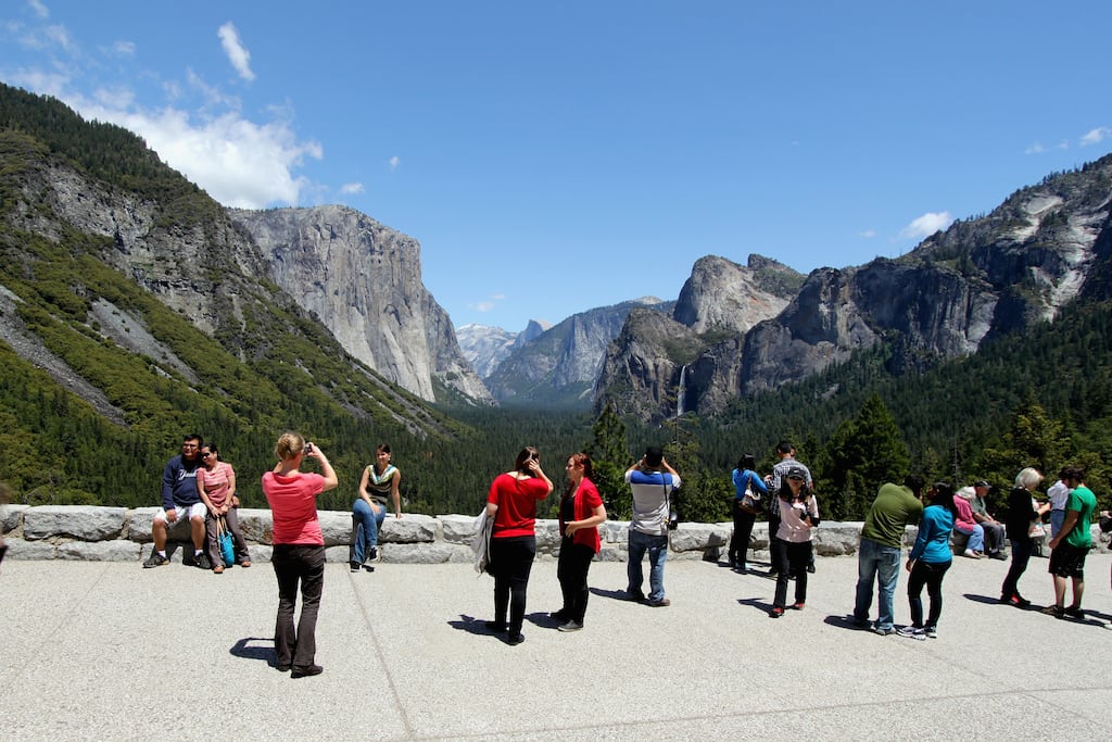 Tourists take photos of the Yosemite Valley in Yosemite National Park in California. 