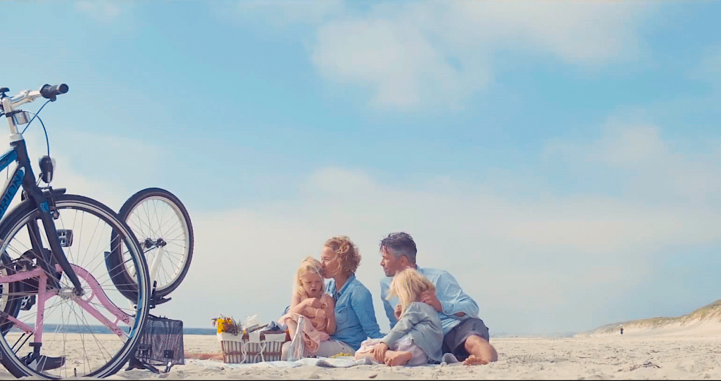 A family rides their bikes to the beach in Visit Denmark's new ad campaign.