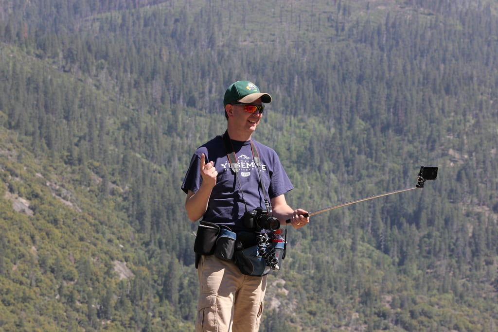 A tourists uses a selfie stick to take a photo of himself at Yosemite National Park in California.