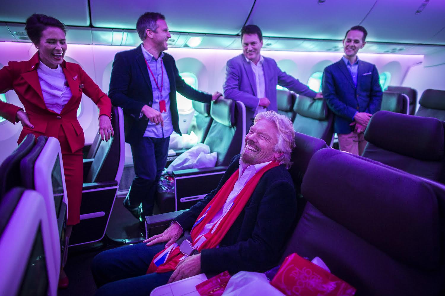 Nik Lusardi (second from left), Virgin Atlantic's design manager for customer experience, briefs Richard Branson about the perks on board the airline's first 787 Dreamliner in Atlanta October 24, 2014. 