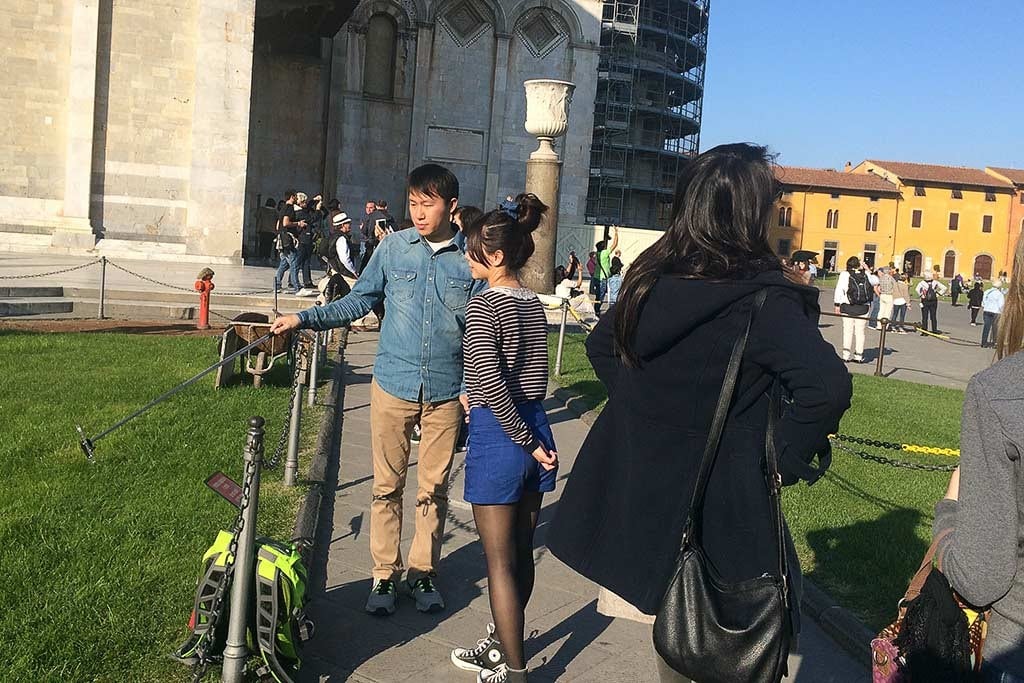 Tourists in Pisa, Italy use a selfie stick. 