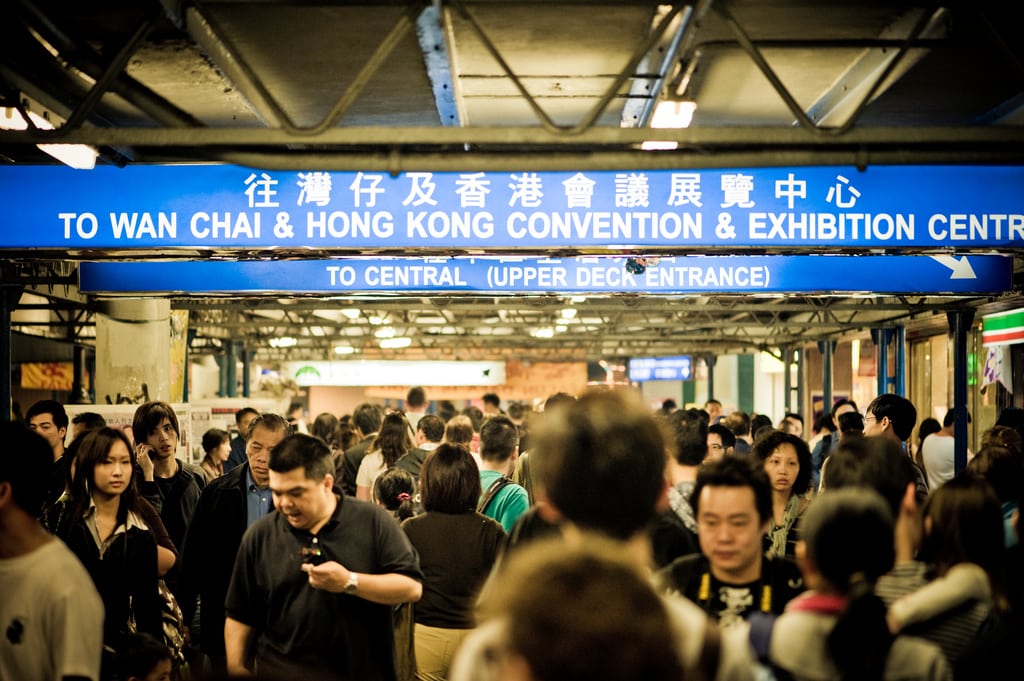 Tourists walk through the Wan Chai & Hong Kong Convention & Exhibition Center. 