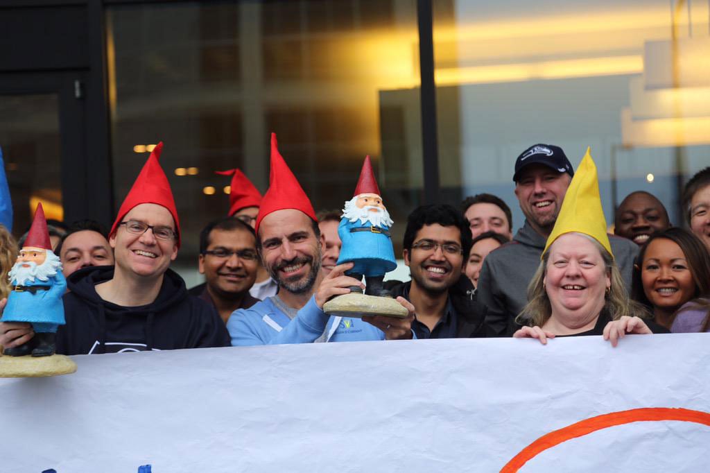 Expedia CEO Dara Khosrowshahi, center, celebrating the acquisition of Travelocity by donning a gnome cap and lifting the Roaming Gnome. 