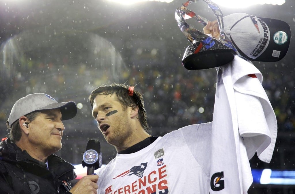 New England Patriots quarterback Tom Brady, right, holds the championship trophy while being interviewed by Jim Nance after the NFL football AFC Championship game Sunday, Jan. 18, 2015, in Foxborough, Mass.