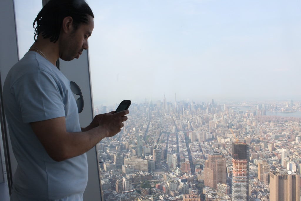 A tourist using his smartphone at the new 1 World Trade Center Observatory in New York City.