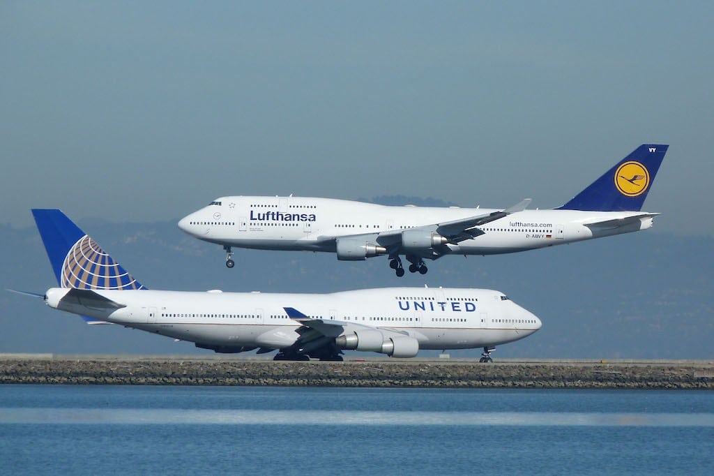 A Lufthansa aircraft lands while a United aircraft taxis in San Francisco.