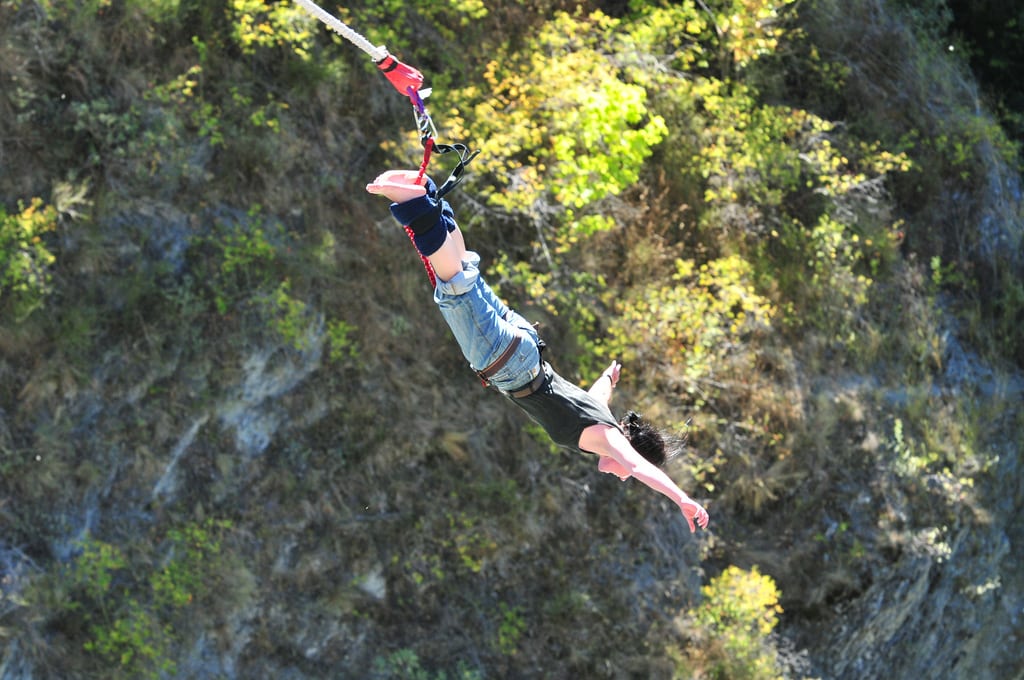 A Chinese traveler bungee jumping off a bridge over the Kawarau River in New Zealand.