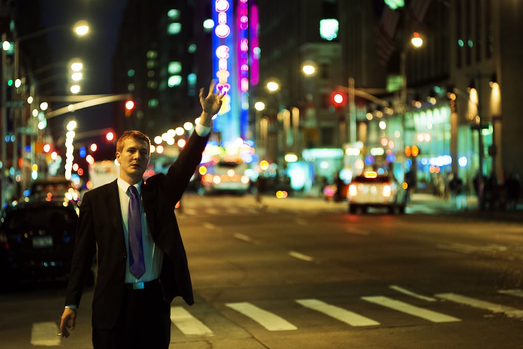A businessman hails a cab at night in Manhattan.