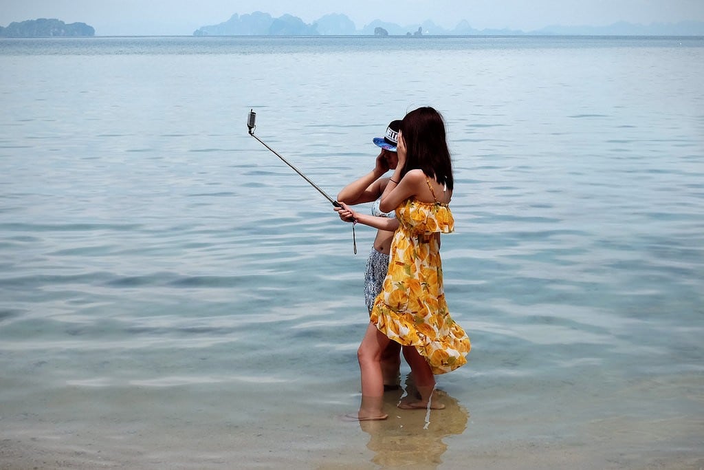 Two Chinese travelers take a selfie on Koh Hong Island, Thailand.