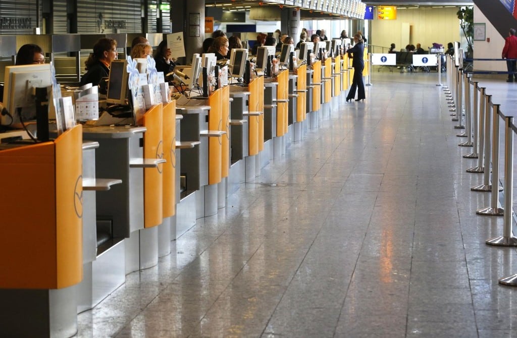 Empty airports like this one at a Lufthansa counter are the new reality, as companies join in travel bans. 