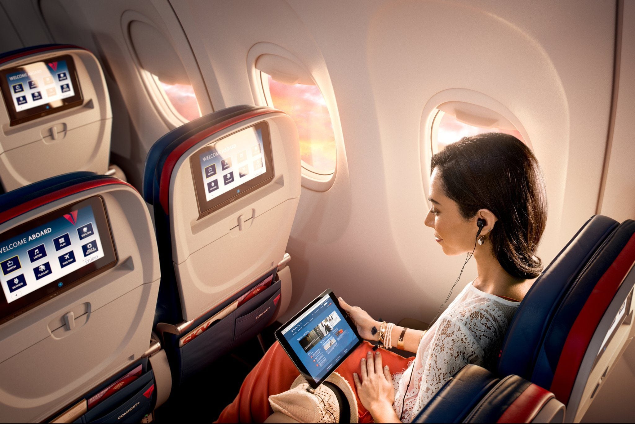 A promotional image of a passenger with many screens at her disposal. 