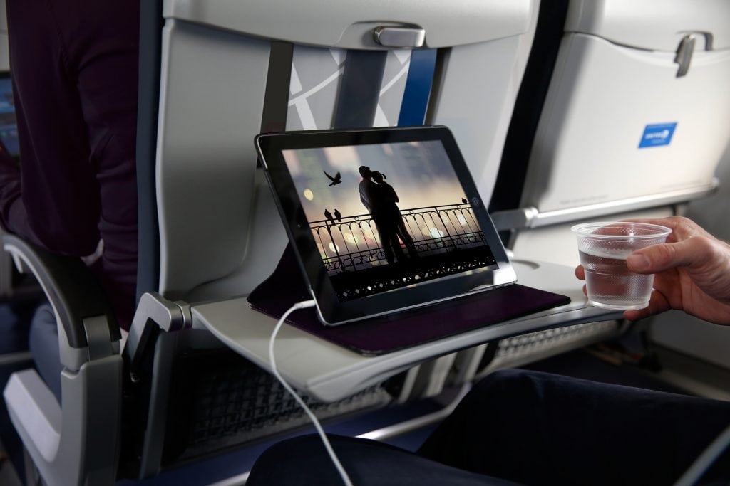 A passenger uses an iPad on a United Airlines flight. iPads are banned on some U.S.-bound flights from the Middle East, but the DHS secretary said Tuesday the ban may not be expanded to other routes.