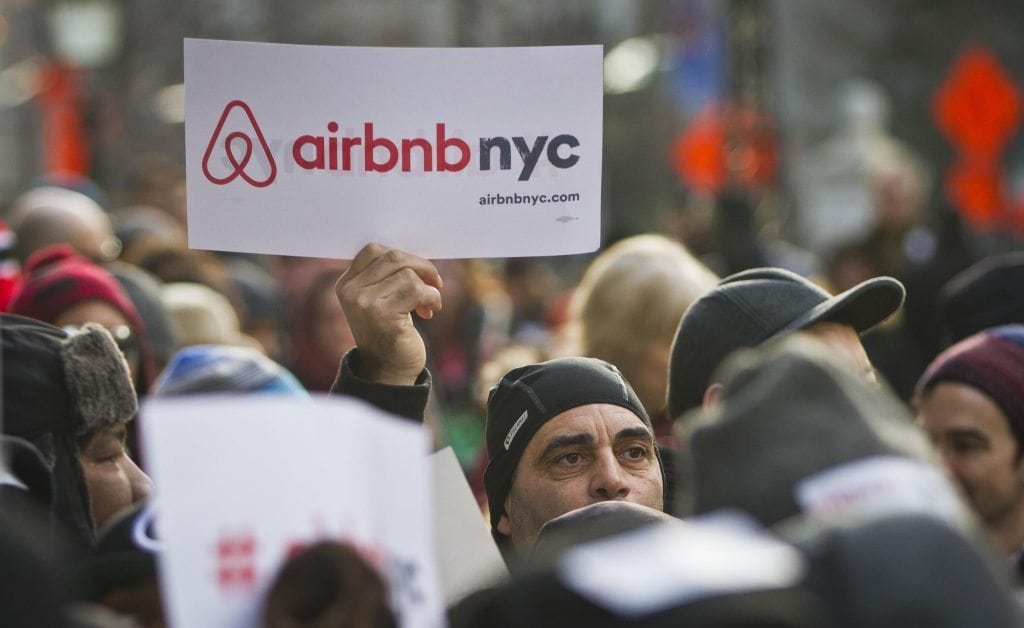 In this Jan. 20, 2015, file photo, supporters of Airbnb hold a rally outside City Hall in New York. The New York state Senate has cleared a bill that would fine hosts who list illegal short-term rentals on platforms like Airbnb, HomeAway, and FlipKey. 