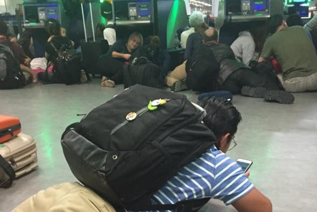 Arriving passengers in the passport control area of New York's Kennedy Airport stay close to the ground after authorities ordered them to get down on the floor in fear of a possible shooter on the loose. 