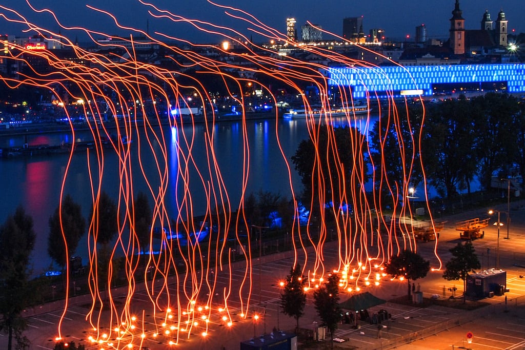 In this time-elapsed photo, 100 synchronized LED drones launch at the ArsElectronica Festival in Linz, Austria.