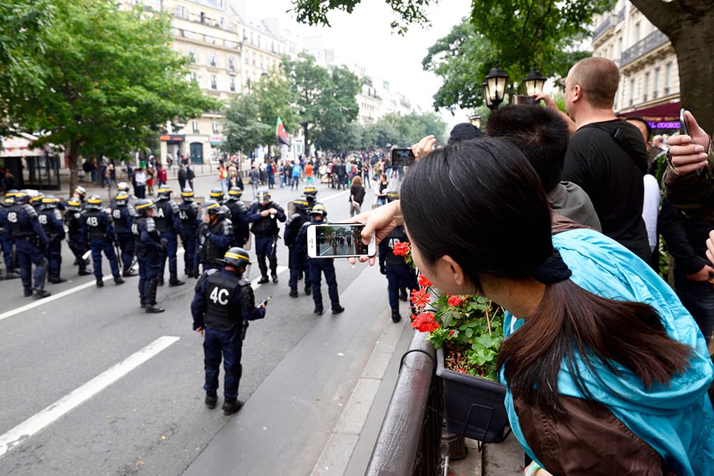 Tourists watching police and protesters in central Paris, whose tourism suffered this summer, on September 15, 2016. 