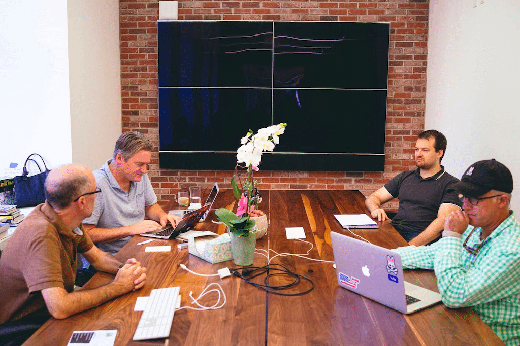 A new biography chronicles the life and work of Paul English, who co-founded Kayak. Pictured, English (second from left) collaborates with co-workers at Lola's Boston offices.