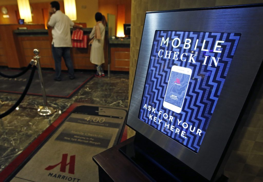 In this October 14, 2014 photo, a mobile check-in option is offered for travelers at the main check-in counter at the Marriott Marquis Times Square hotel in New York.