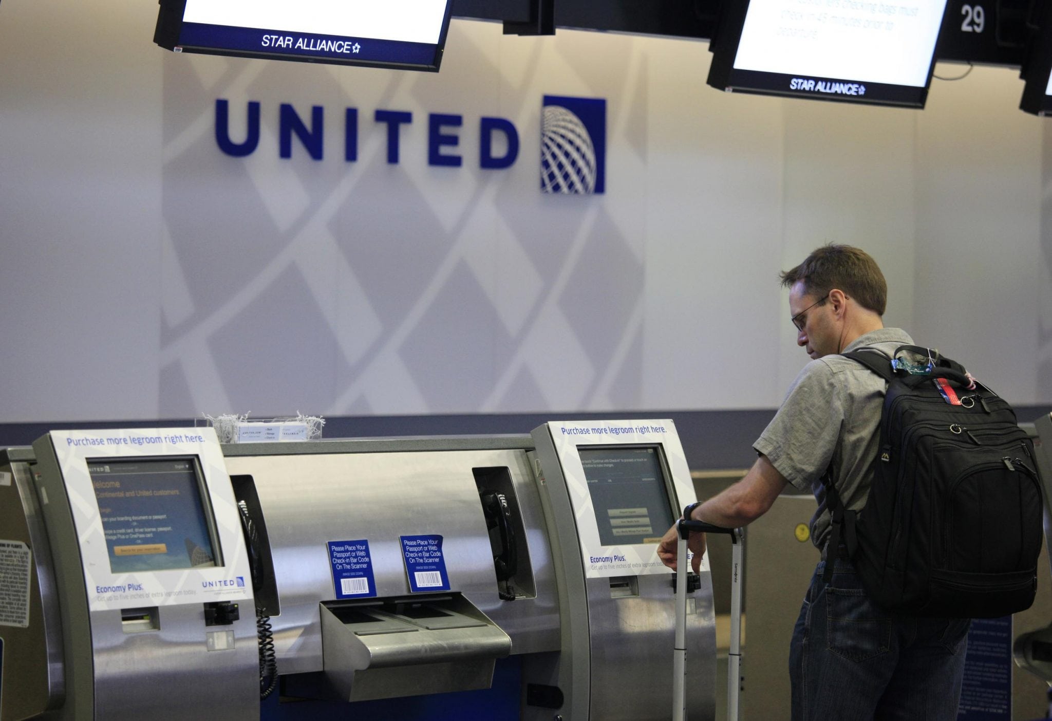 A United Airlines customer uses an airport kiosk. The airline's CEO said United is doing what it can to improve its IT infrastructure. 