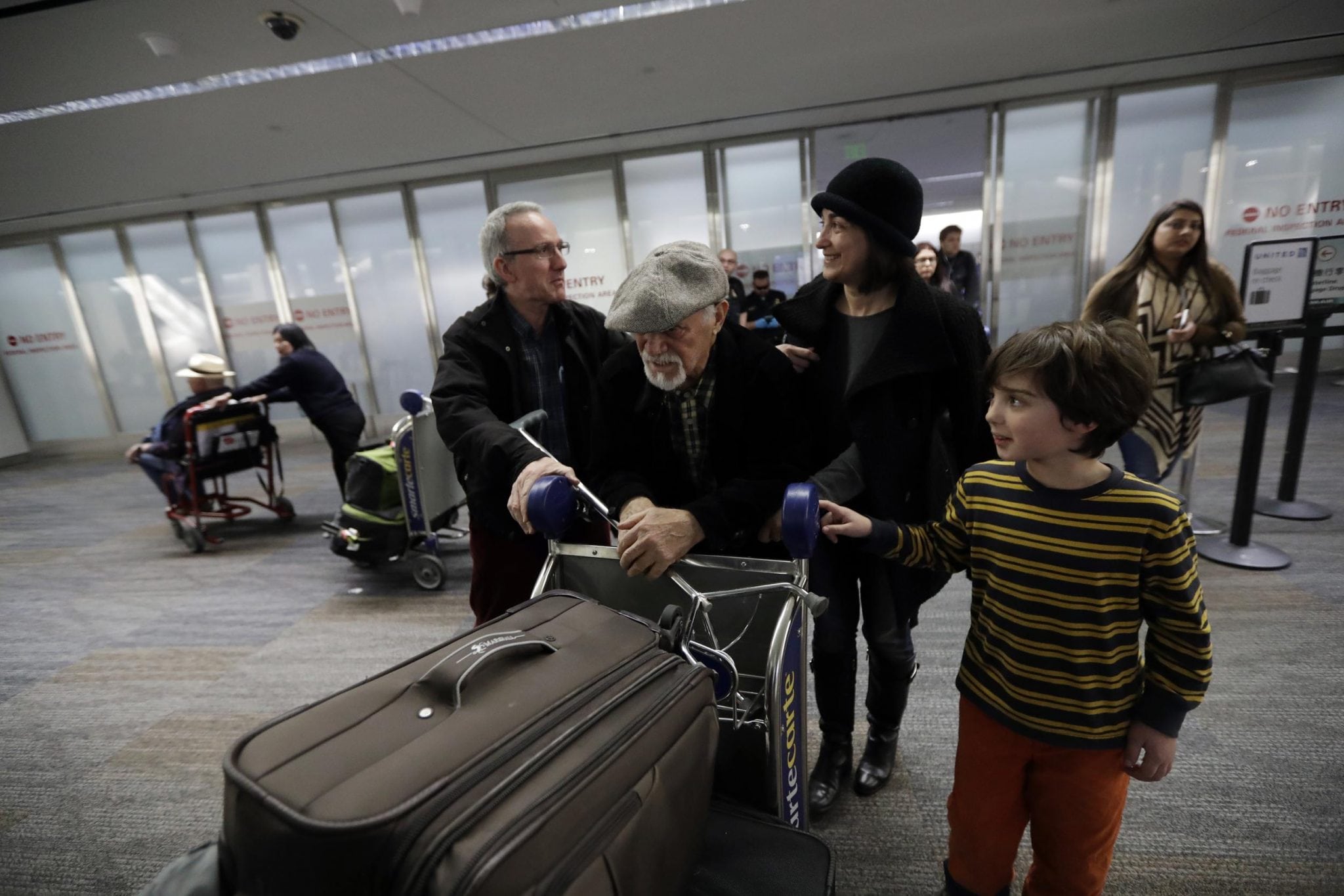 Abdollah Mostafavi, center, arriving from Tehran, Iran, is met by his family at San Francisco International Airport in San Francisco. Mostafavi was held at the airport for some time as a result of President Donald Trump's executive order. 