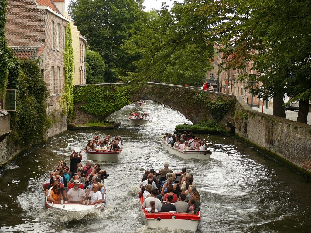 Many residents in Bruges, Belgium support tourism but challenges remain. Pictured are tourists taking boat rides in a canal in Bruges.